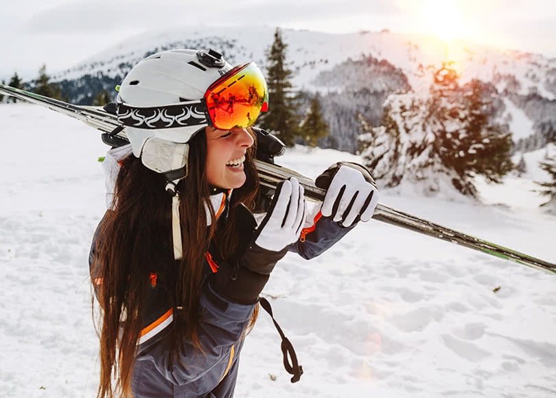 woman-carrying-skis-810x580